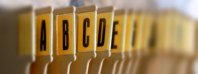 Close-up view of alphabetical file dividers labelled A to H in an organised filing system.