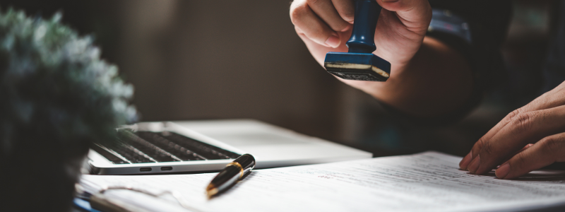 A close up of someone about to stamp paperwork.