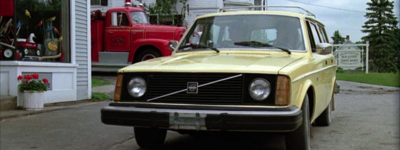 The yellow car from Beetlejuice parked in front of a shop.