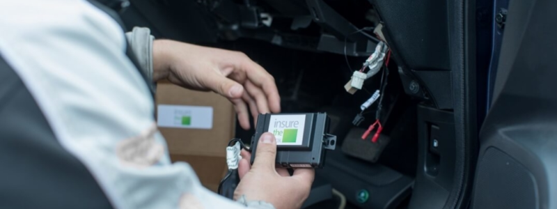 Exposed wiring in a car whilst someone attempts to fit a black box device.