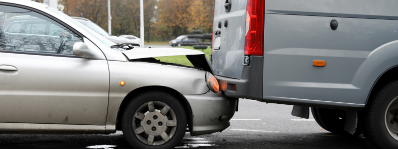 A car collided into a van in front, with the front bonnet damaged, but nothing else seriously damaged, symbolising a minor crash.