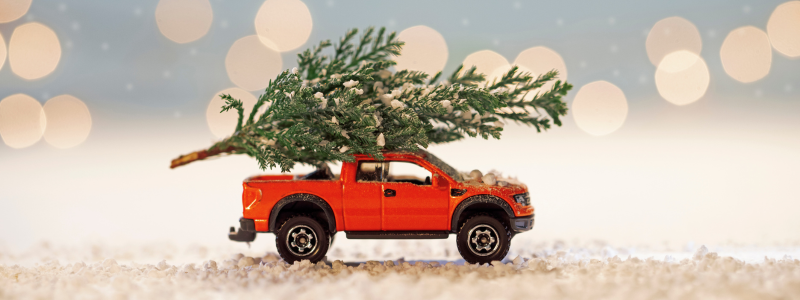 A toy car with a Christmas tree on top.