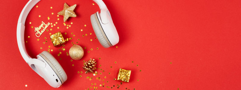 Headphones alongside Christmas decorations and ornaments, representing Christmas music.