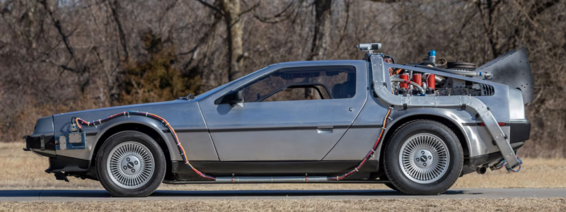 The iconic DeLorean vehicle parked in a rural setting.