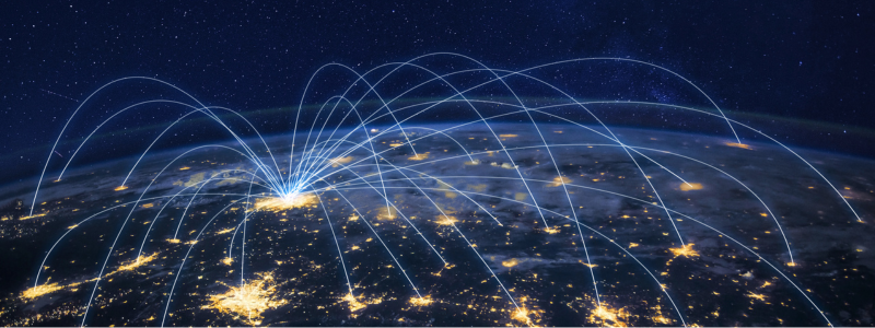 Night view of Earth from space with glowing city lights and blue lines connecting different locations, symbolising global distribution.