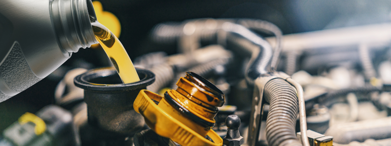 Oil being poured into an engine oil cap.