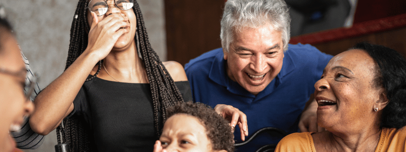 A family of all ages laughing together, symbolising togetherness, family and happiness.