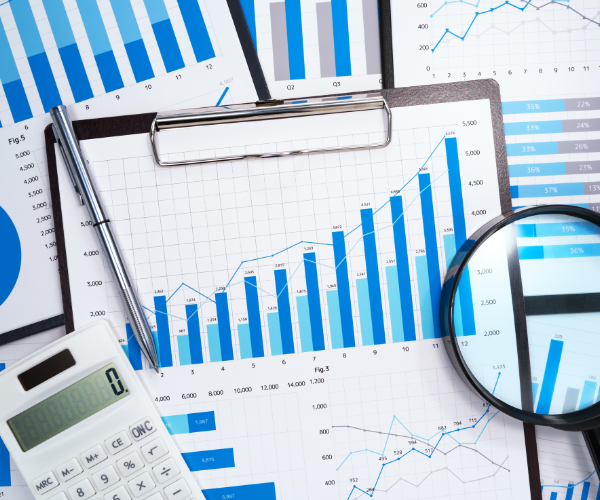 Various analysis charts, a calculator and a magnifying glass, signalling business sales.