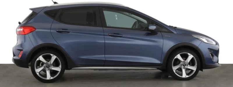 A side-on view of a blue Ford Fiesta Active parked against a white background.