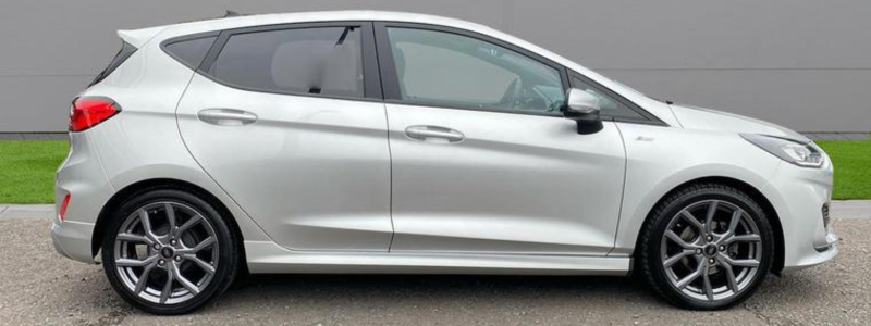 A grey Ford Fiesta Startline parked against a grey background outdoors.