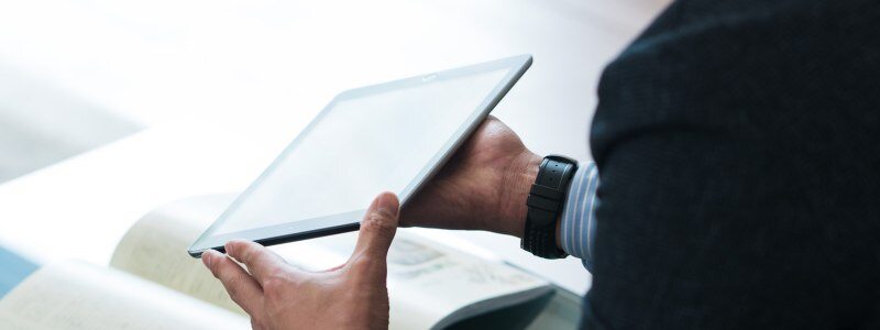 A car salesman holding a tablet