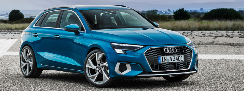 A blue Audi A3 parked up on an open road.