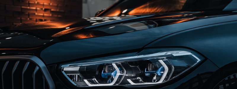 Close-up of a BMW vehicle's front headlight and grille, highlighting the car's luxury design,