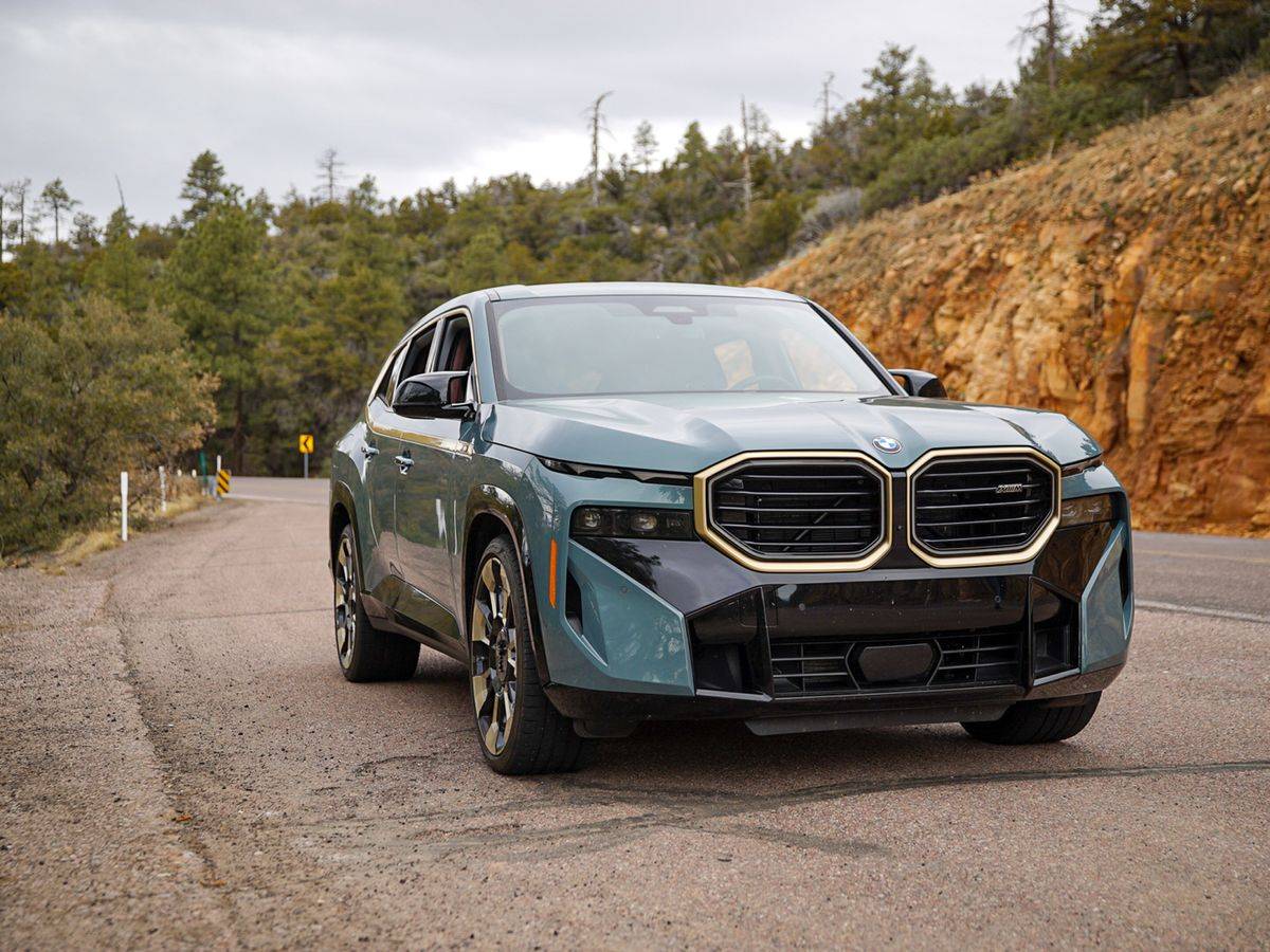 The BMW XM in blue on an open road.