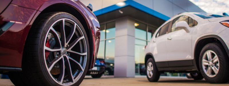 An upward shot of a car dealership, with cars outside.