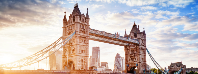 Westminster Bridge with sun shining and London buildings in the background.