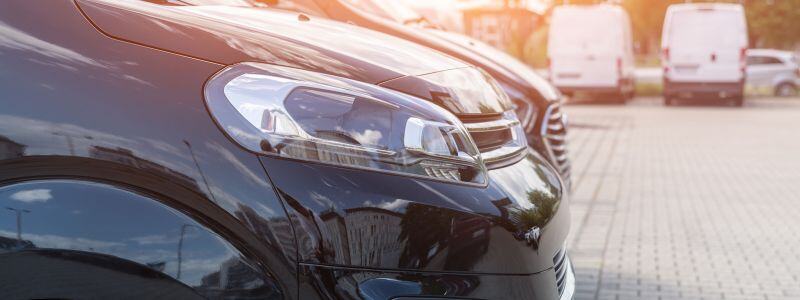 A row of cars with sun shining on them.