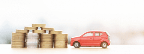 A small toy car next to a stack of coins.