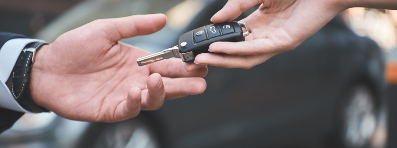 Car keys being handed from one person to another.