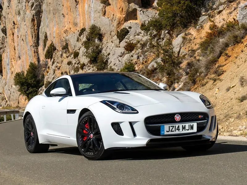 A white Jaguar F Type on a hillside road.