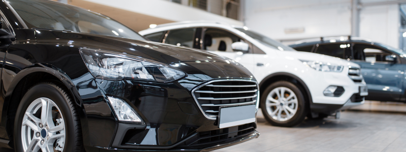 Close-ups of new cars in a showroom.