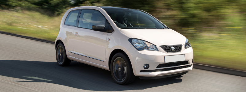 A white Seat Mii on a road.