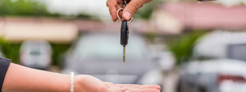 Car keys being exchanged between two people.