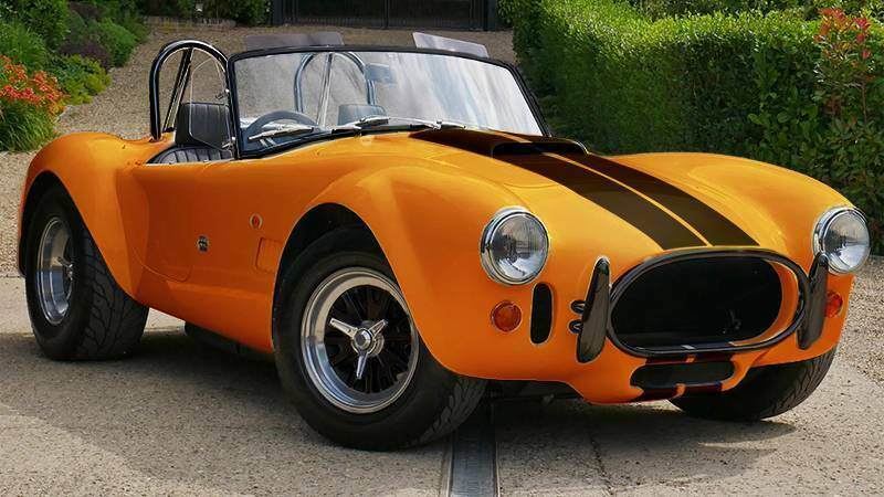 The AC Cobra EV+ parked in orange with black stripes.