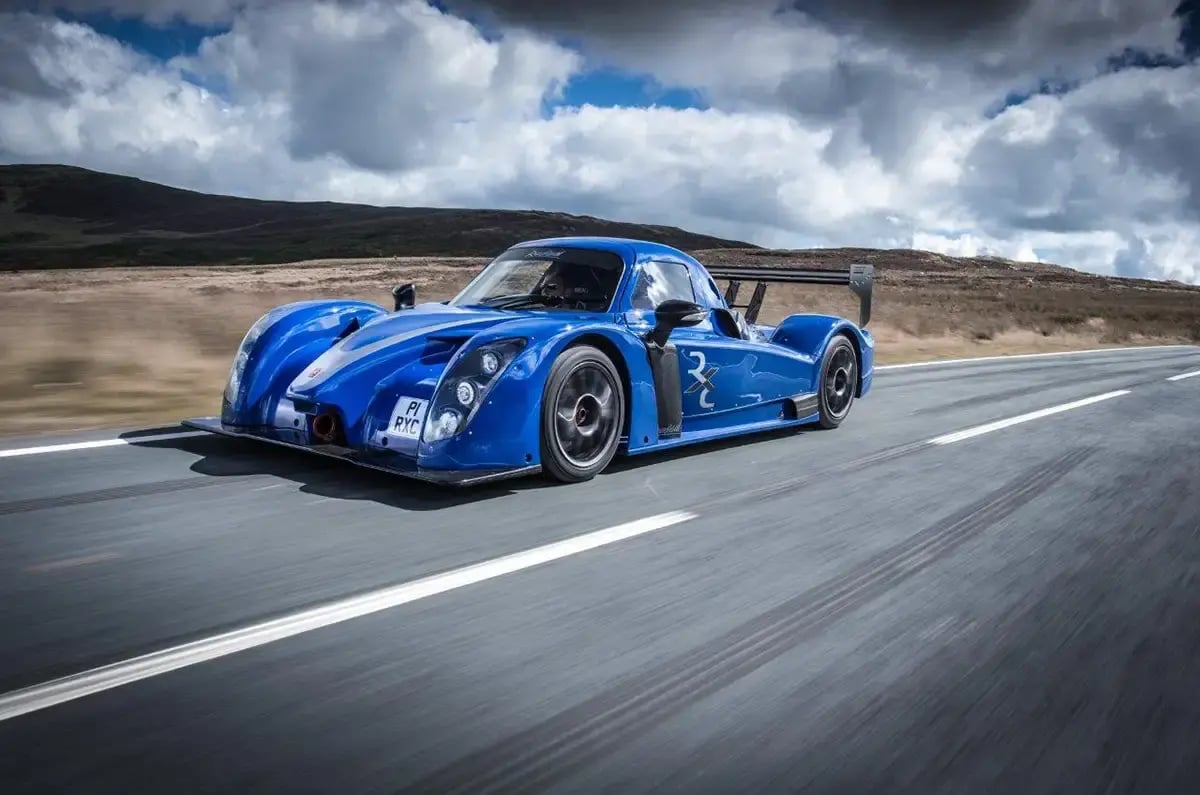 A Radical RXC GT in red driving on a road.