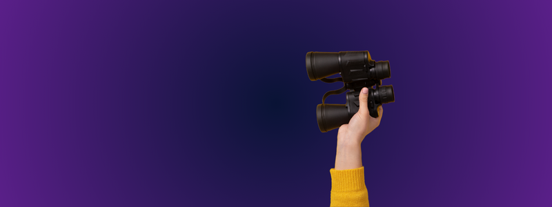 Hand holding binoculars against a purple gradient background, symbolising exploration, searching, and looking ahead to new opportunities.