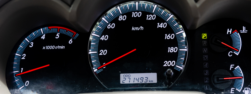 A close-up of a car dashboard displaying speed, mileage and other metrics.