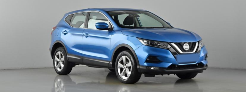 A light blue Nissan Qashqai parked side-on against a grey background, likely in a car showroom.