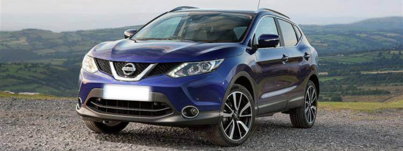 A blue Nissan Qashqai parked against a rural, countryside background, displaying the Qashqai's off road ability.