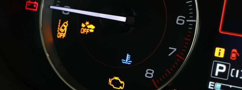 Car dashboard with illuminated warning lights including oil, engine, and temperature indicators.