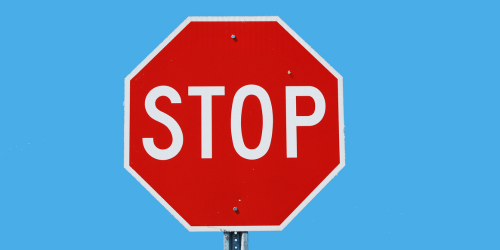 A red stop sign stood up, with a sky blue background.