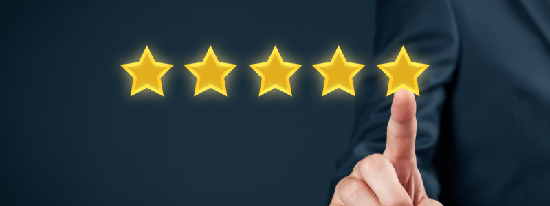 Person pointing at a row of five gold stars, symbolising a five-star review or rating.