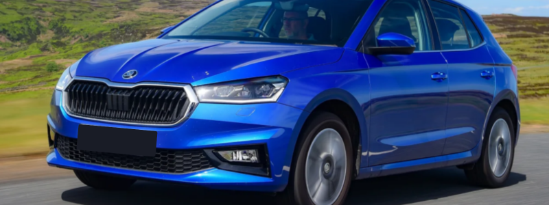 A blue Skoda Fabia driving on a rural road in day time.