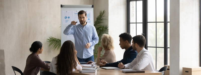 People seated with one person stood up talking, likely part of a work training session.