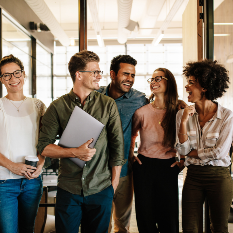 A team walking through an office laughing and smiling with each other