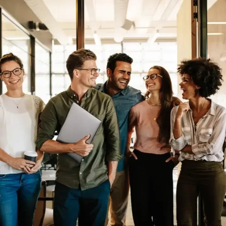 A team walking through an office laughing and smiling with each other