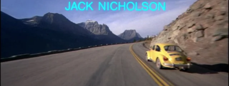 A yellow car driving round a hillside road, with 'Jack Nicholson' written above, as part of the film the Shining.