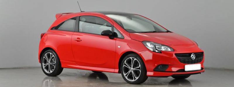 A red Vauxhall Corsa parked against a grey background.