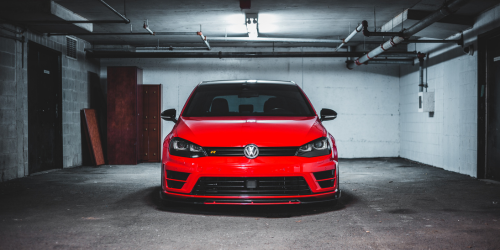 A red car sitting in an empty garage